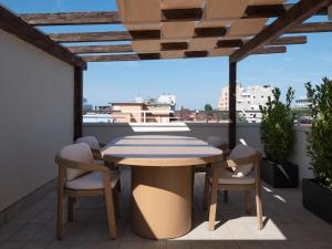a table and chairs on a balcony with a view at Fill's Luxury Design Apartments 100m from the Beach in Rimini