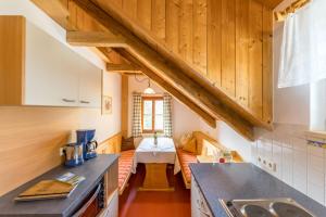 a kitchen with a counter and a table in a room at Schmiedlehnerhof in Birnberg