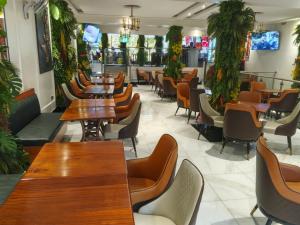a restaurant with tables and chairs and plants at Bonds Hotel in Nairobi +23 photos