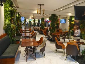 a restaurant with tables and chairs and a bar at Bonds Hotel in Nairobi