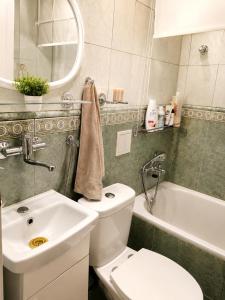 a bathroom with a toilet and a sink and a tub at Mieszkanie Warka in Warka +2 photos