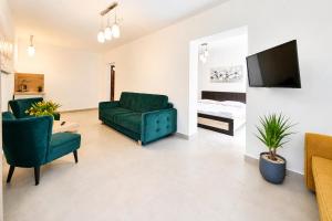 a living room with a green couch and a tv at Dom Wczasowy GLOBUS in Ustroń