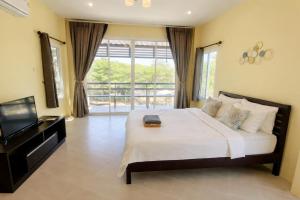 a bedroom with a large bed and a television at Koniix Garden Cottage Ko Sichang in Ko Si Chang