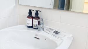 a white sink with two bottles of wine on it at Koniix Garden Cottage Ko Sichang in Ko Si Chang