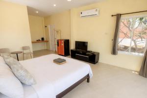 a bedroom with a bed and a tv and a window at Koniix Garden Cottage Ko Sichang in Ko Si Chang +11 photos