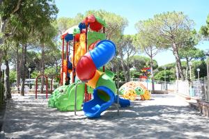 a playground in a park with a slide at Campeggio del Forte in Marina di Bibbona