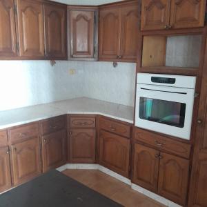 a kitchen with wooden cabinets and a white oven at Rejiche in Rejiche +11 photos