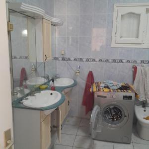 a bathroom with two sinks and a washing machine at Rejiche in Rejiche