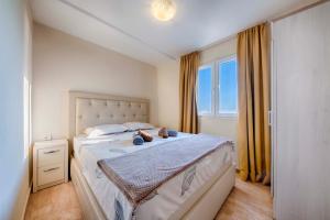 a bedroom with a bed with two stuffed animals on it at ZIS LUX Apartments Pool in Utjeha