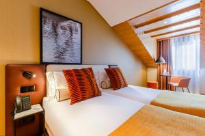 a bedroom with a bed with orange and white pillows at Ouro Rossio Hotel in Lisbon +35 photos