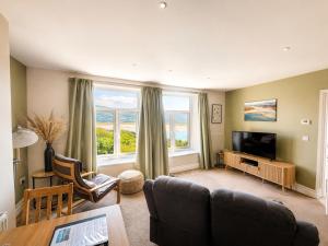 a living room with a couch and a television at Bryn Melyn Apartments in Barmouth