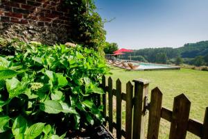 a wooden fence in front of a yard with a pool at LA HAUTE FORGE - Maison d'hôtes in Thoiré-sur-Dinan