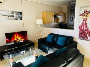 a living room with a couch and a fireplace at Prestige Apartments Sandton at Westpoint in Johannesburg