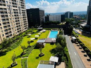 an aerial view of a park with a pool in a city at Prestige Apartments Sandton at Westpoint in Johannesburg