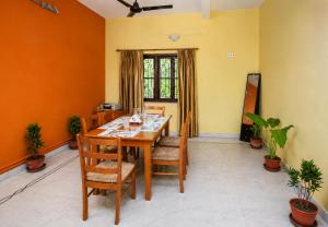 a dining room with a wooden table and chairs at Next Generation Guest House in kolkata