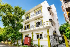 a white building with a red box in front of it at Next Generation Guest House in kolkata