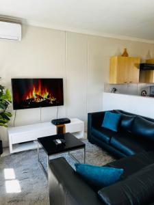 a living room with a couch and a fireplace at Prestige Apartments Sandton at Westpoint in Johannesburg