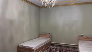 a room with two beds and a chandelier at Bars guest House in Barskoon