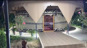 a gazebo with a table and some plants at Bars guest House in Barskoon