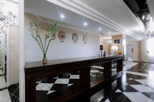 a lobby with a counter with a vase of flowers at Hotel Gloria in Kostanay +74 photos