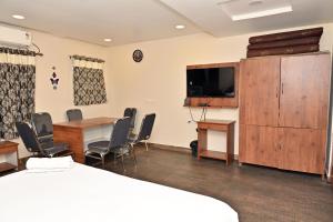 a room with a conference room with a table and a tv at Hotel Ganesh Mahalakshmi Inn in Guntūr +16 photos