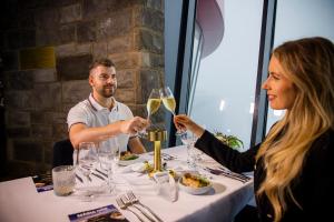 a man and woman sitting at a table with wine glasses at Noc na Chopku, Rotunda in Belá