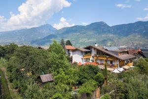 a house on a hill with mountains in the background at Hotel FleurAlp in Cermes