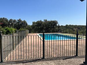 a metal fence with a pool behind it at Finca Los Majadales in Almodóvar del Río