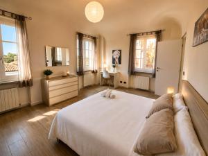 a bedroom with a large white bed and windows at Novi Outlet Apartment in Novi Ligure