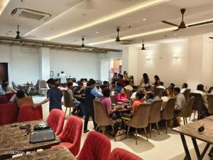 a group of people sitting at tables in a room at HOTEL AUGUSTO in Varanasi
