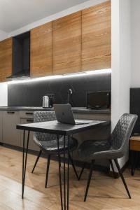 a kitchen with a table with a laptop on it at Apartel Shayan in Shaian +4 photos