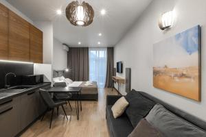 a kitchen and a living room with a couch and a table at Apartel Shayan in Shaian