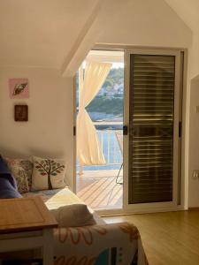 a bedroom with a bed and a door to a balcony at SEAWAY in Zavalatica