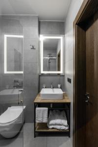 a bathroom with a sink and a toilet and a mirror at Apartel Shayan in Shaian