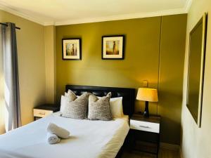 a bedroom with a white bed with green walls at Prestige Apartments Sandton at Westpoint in Johannesburg +255 photos