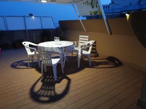 a table and chairs on a balcony with an umbrella at Terrazza con vista in Nettuno