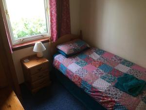 a small bedroom with a bed and a window at Buzzards Nest Cottage in Roybridge