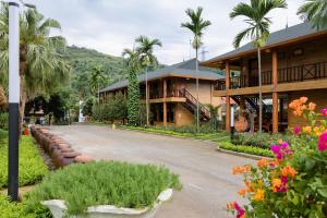 a street in front of a building with palm trees and flowers at Hoa Binh Resort in Hòa Bình