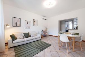 a living room with a white couch and a table at Maddy's House in Mandello del Lario
