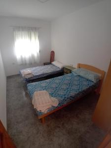 a bedroom with two beds and a window at COSTACABANA Apartamento in Almería +4 photos