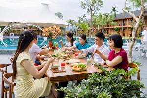 a group of people sitting around a table eating food at Hoa Binh Resort in Hòa Bình
