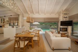 a kitchen and living room with a table and a couch at Villa Carina by TwentyTwo in Ancient Epidauros