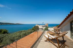 a balcony with chairs and a view of the water at Villa Carina by TwentyTwo in Ancient Epidauros