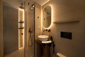 a bathroom with a sink and a shower with a mirror at Villa Carina by TwentyTwo in Ancient Epidauros +82 photos