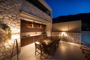 a kitchen and dining room with a wooden table and chairs at Villa Carina by TwentyTwo in Ancient Epidauros