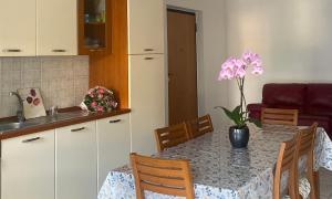 a kitchen with a table with a vase of flowers on it at Gioia Casa in Pizzo
