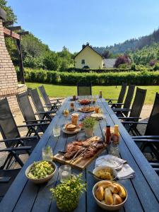 a long wooden table with plates of food on it at Ferienhaus im Wiesengrund in Simmerath