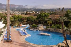 a swimming pool with lounge chairs and a resort at BLUESEA Costa Jardin & Spa in Puerto de la Cruz