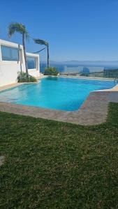 a swimming pool in front of a house at Exclusive luxury villa private pool and garden mnar in Tangier