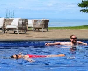 a man and a woman swimming in a swimming pool at Barsebäck Resort Hotell in Löddeköpinge